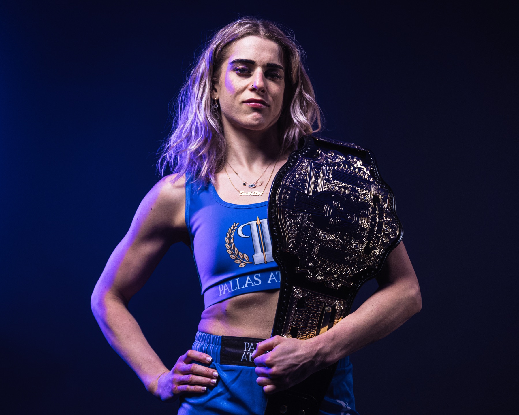 Kate Bacik standing with her championship belt over her shoulder