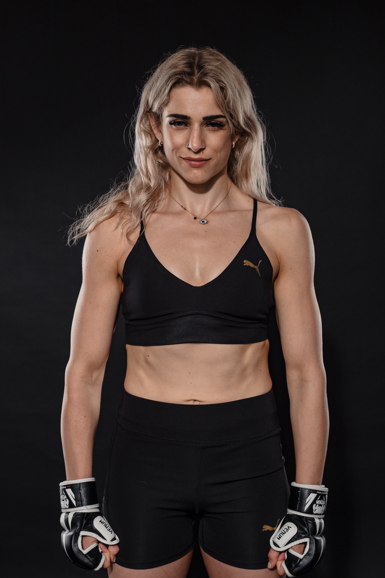 Kate Bacik in training kit and MMA gloves against a black backdrop
