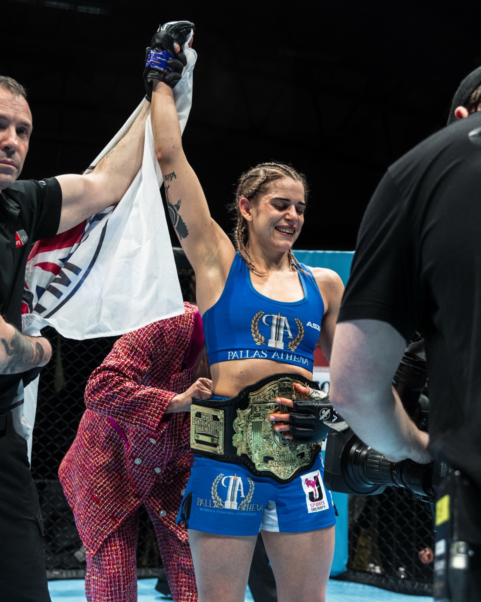 Kate Bacik with the championship belt around her waist as the referee raises her hand